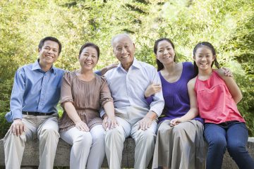 Three Generation Family Sitting in their Apartment Courtyard